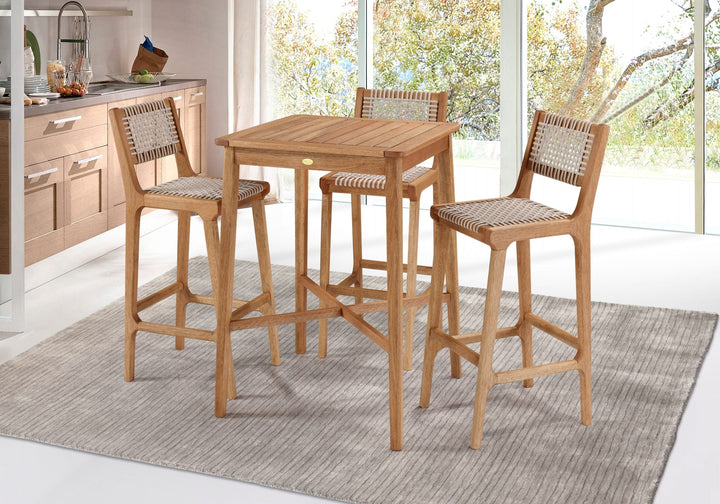 Três banquetas altas de madeira maciça com assento de corda náutica e apoio de pé, em torno de uma mesa alta, ao lado de uma bancada de cozinha